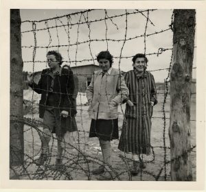 Trois femmes derrière les barbelés au camp de Bergen-Belsen à la fin de l'Holocauste, 1945.