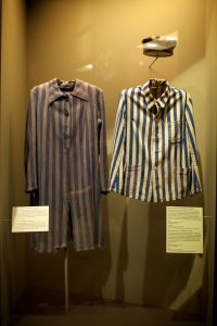 Deux uniformes de prisonniers de camps de travaux forcés exposés dans l'exposition permanente du Musée de l'Holocauste Montréal.