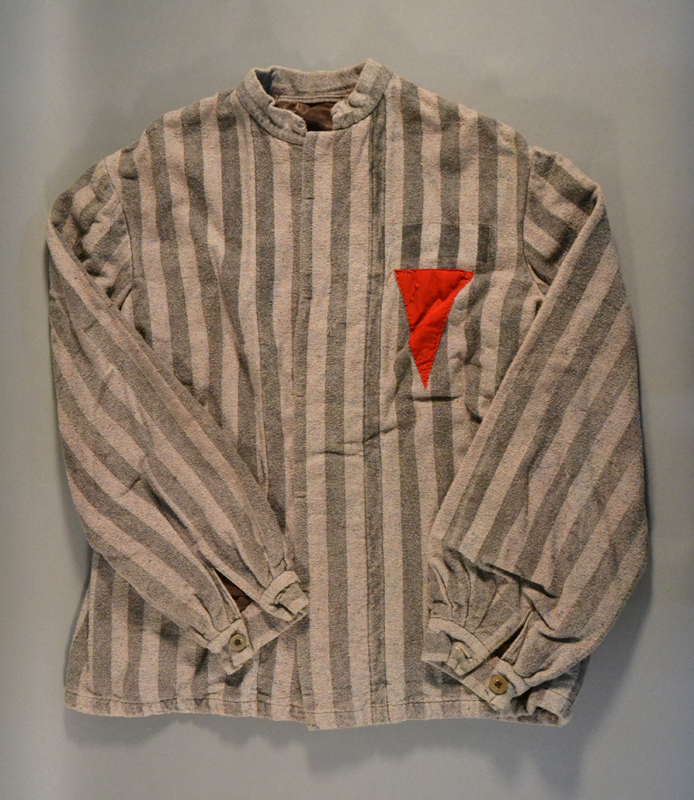 An uniform jacket with a red triangle sewed on the fabric indicating that it belonged to a political prisoner. 