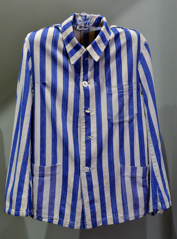 A prisoner’s jacket that once belonged to Zigmund Schick. Made of cotton, white white and cobalt blue stripes, it has five white buttons and three pockets cut from the same striped fabric. In concentration camps, prisoners were required to wear clothing that distinguished them from civilians or military personnel.